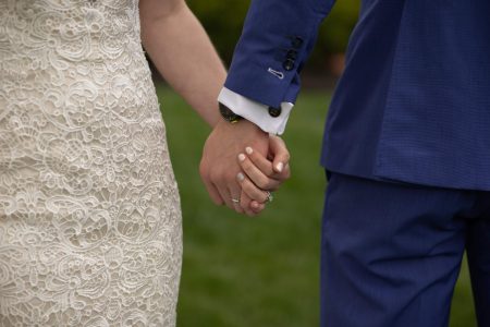 wedding suit holding hands